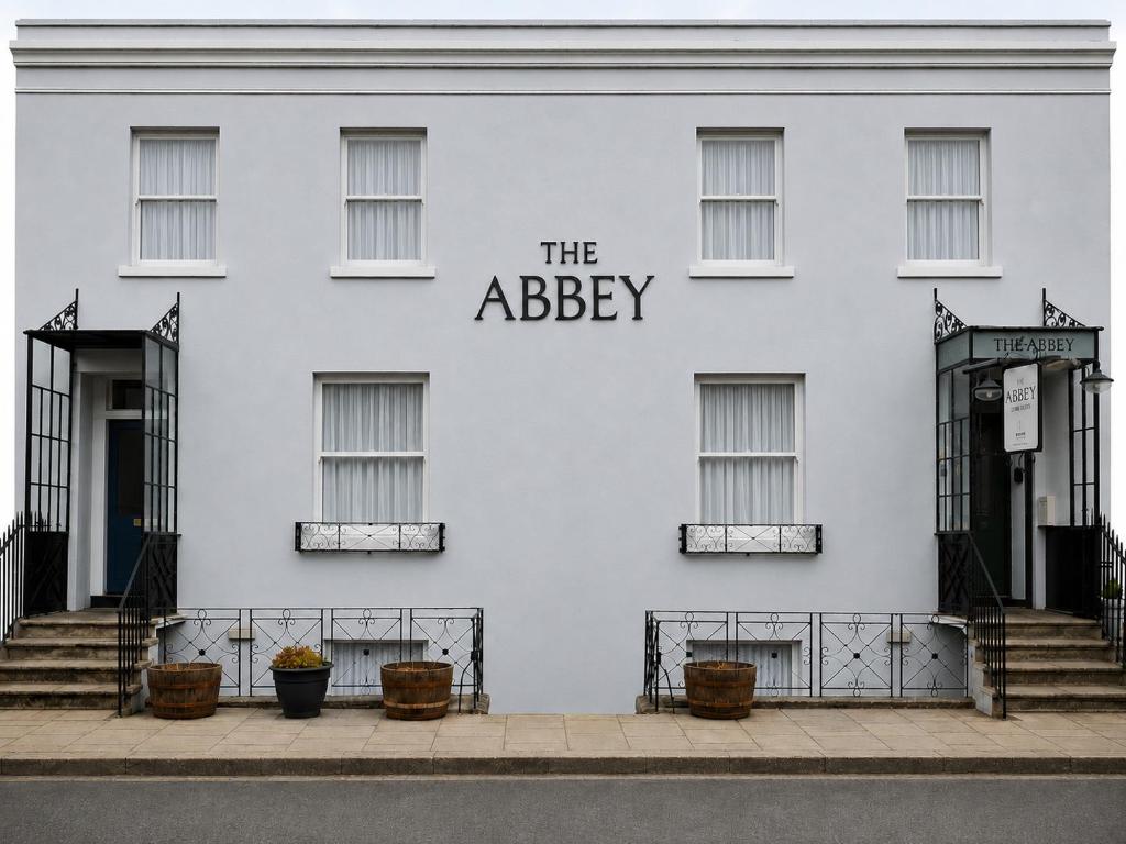 a white building with the abbey sign on it at The Abbey Town House in Cheltenham