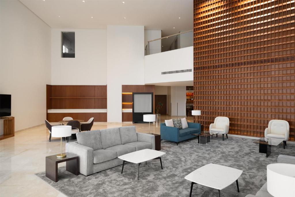 a lobby with a couch and chairs and tables at Park Inn by Radisson Al Khobar in Al Khobar
