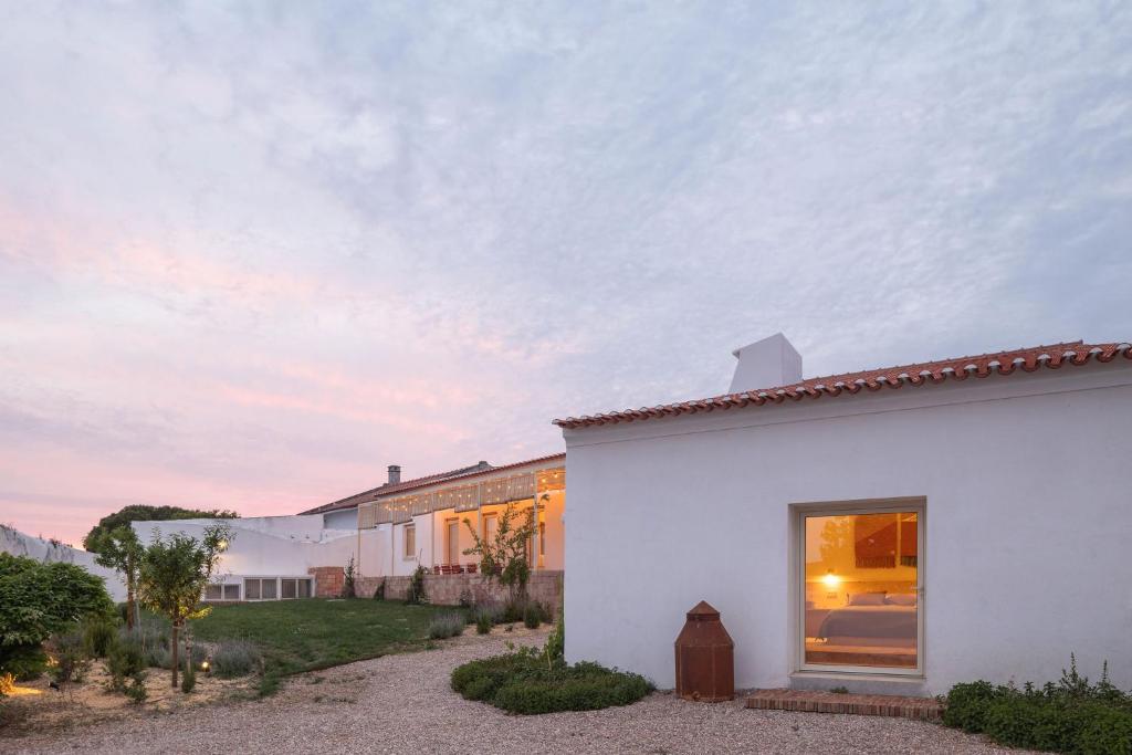 a white house with a window on the side of it at Casa Dez - Pedrogão do Alentejo in Pedrógão