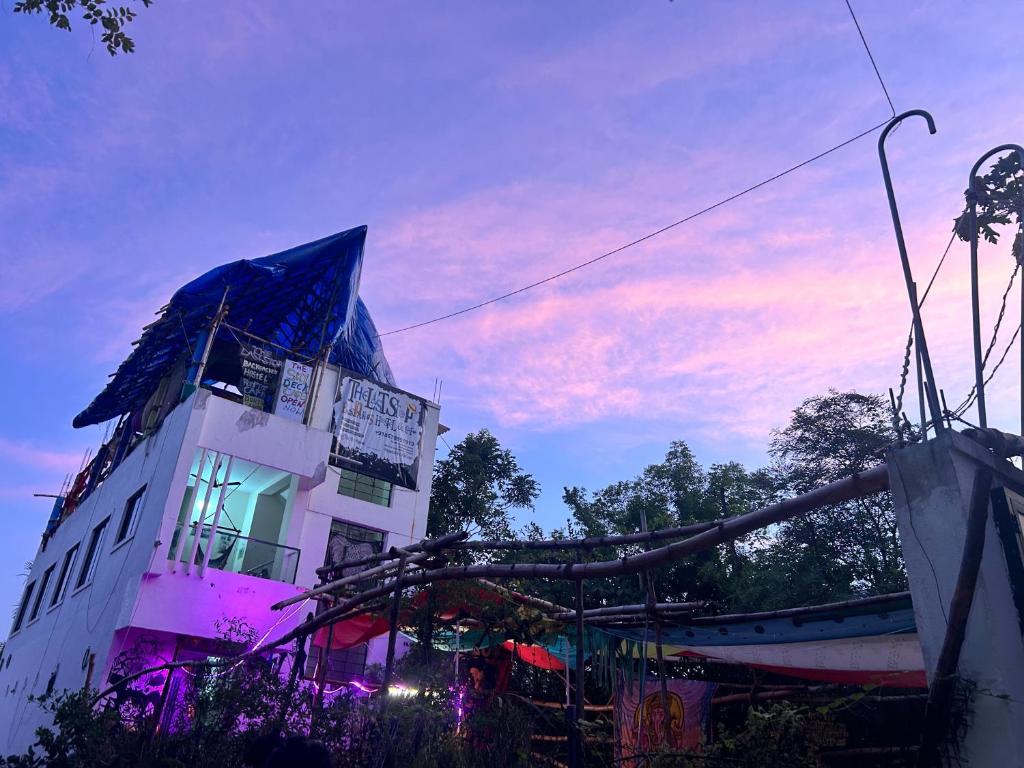 a building with a lit up window in front of it at The Last Stop Backpackers Hostel in Auroville
