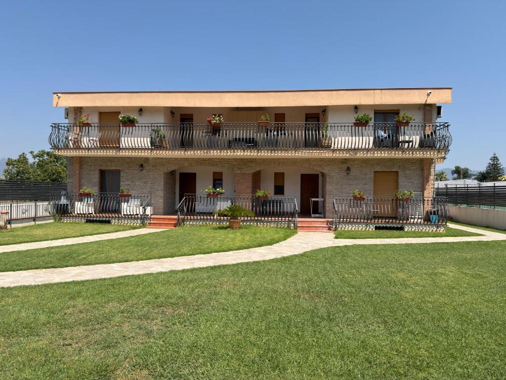 a building with balconies and a lawn in front of it at Villa Anté B&B in Angri