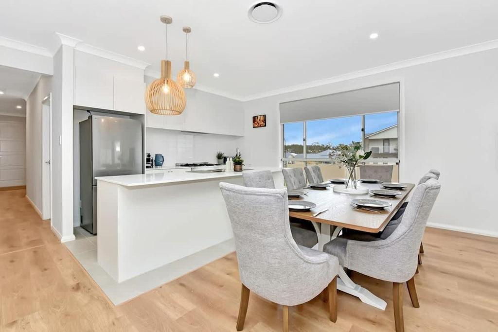 a kitchen and dining room with a table and chairs at Hunter Valley Bercuti in North Rothbury
