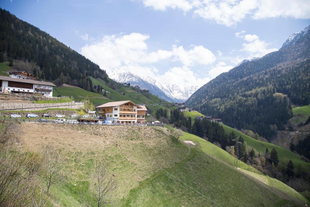una casa al lado de una colina con montañas en Unterer Obereggerhof, en San Leonardo in Passiria