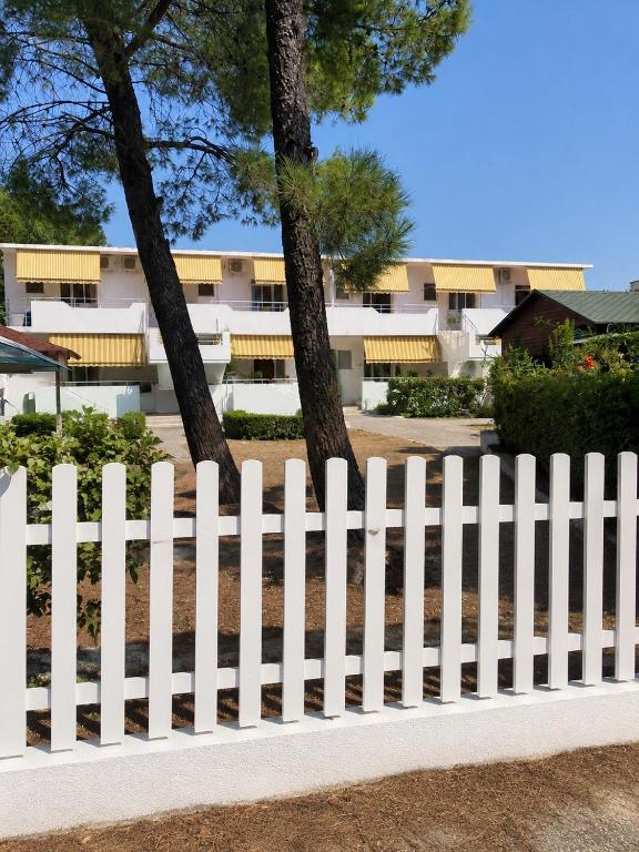 a white picket fence in front of a building at Beachside Apartments Smajlaj in Velipojë