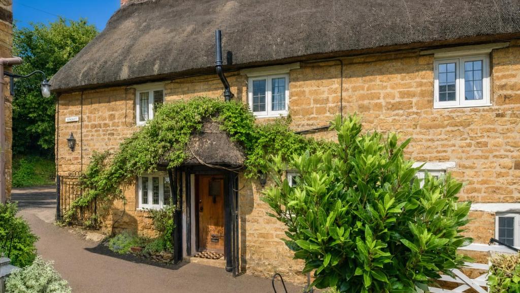 an old brick house with a thatched roof at Suncroft in Shotteswell