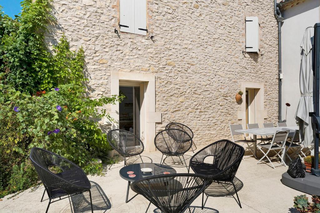 a patio with chairs and a table and a building at Chambres D'hôtes Le Cocon in Saint-Paul-les-Fonts