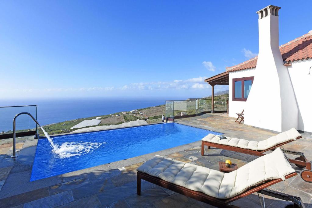 a swimming pool with the ocean in the background at Casa Vista Mar in Tijarafe