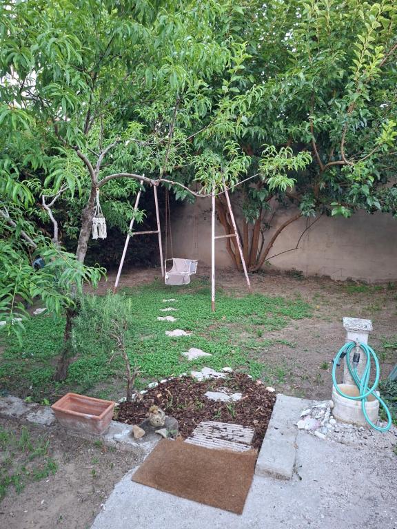 a garden with two trees and a swing at stanza a casa marina in Rosolina