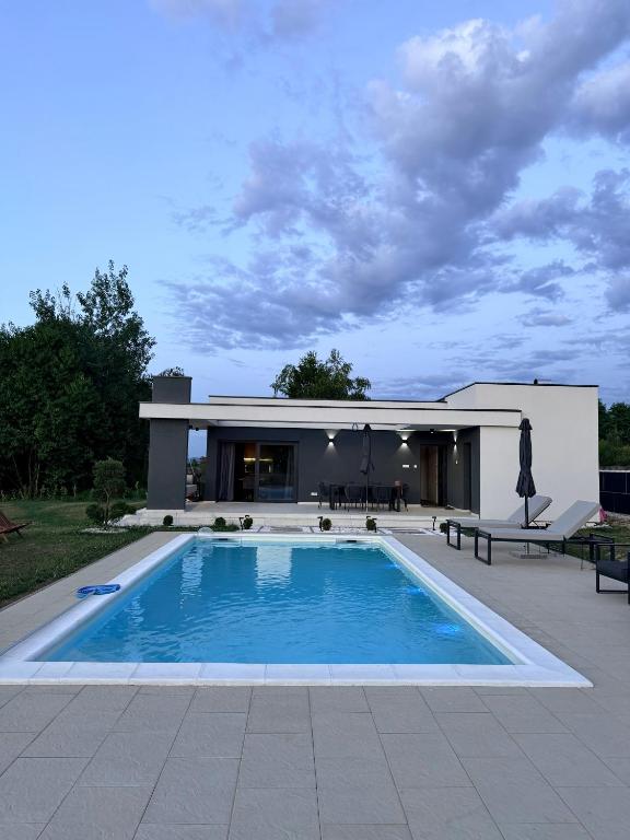 a swimming pool in front of a house at Aurora Noir Retreat in Banja Luka
