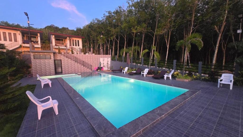 a swimming pool with two chairs and a table and chairs at Samati Best House - Pool Apartments A1 - Klong Ning Beach in Ko Lanta Yai