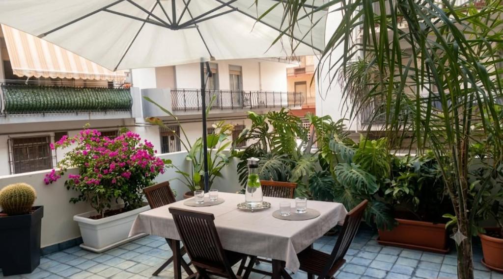a table with chairs and an umbrella on a patio at Casa Luce in Milazzo