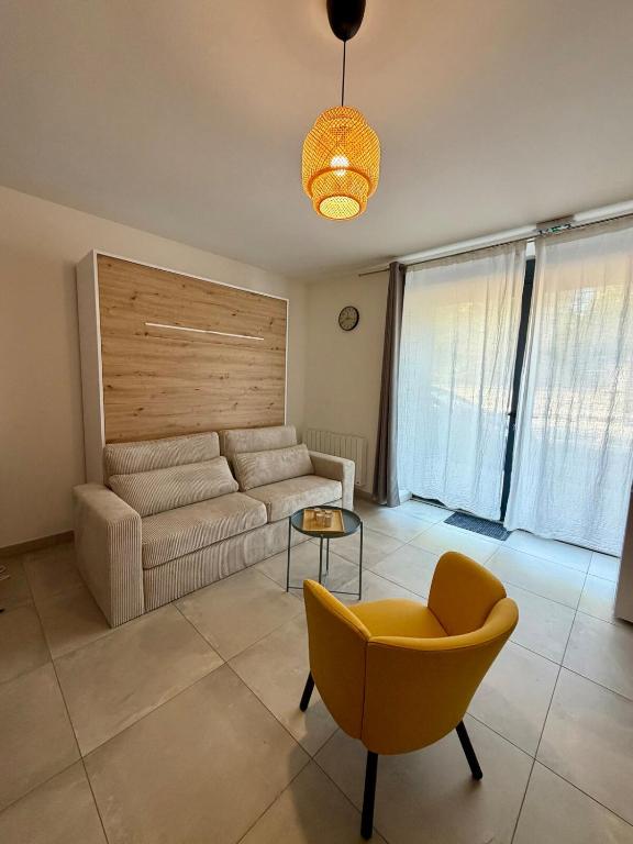 a living room with a couch and a chair at Le Marronnier - Studio confortable proche de Lyon in Charbonnières-les-Bains