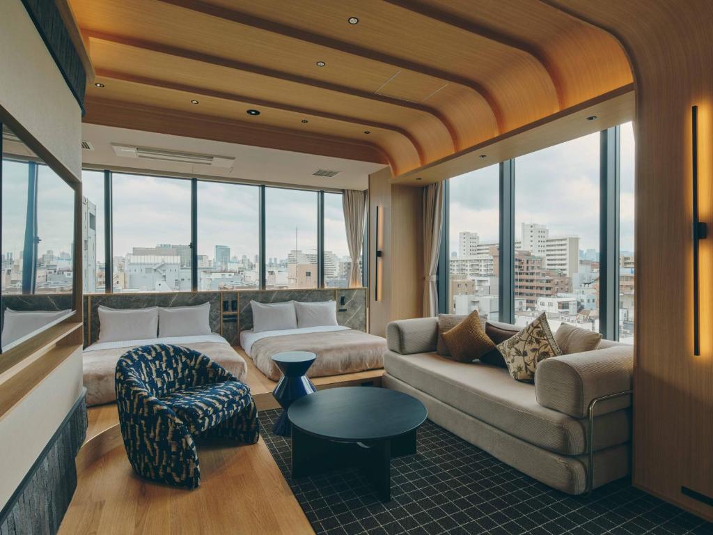 a living room with a couch and chairs and windows at illi Sen Oshiage in Tokyo