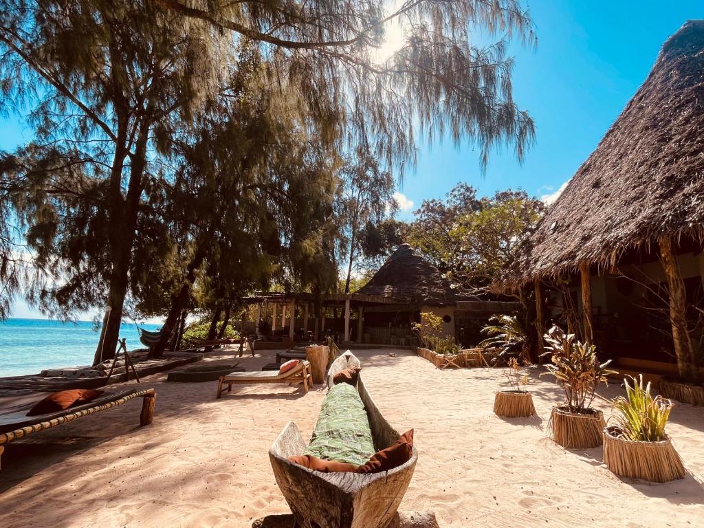 a boat sitting on the sand on a beach at Mama Root in Kizimkazi