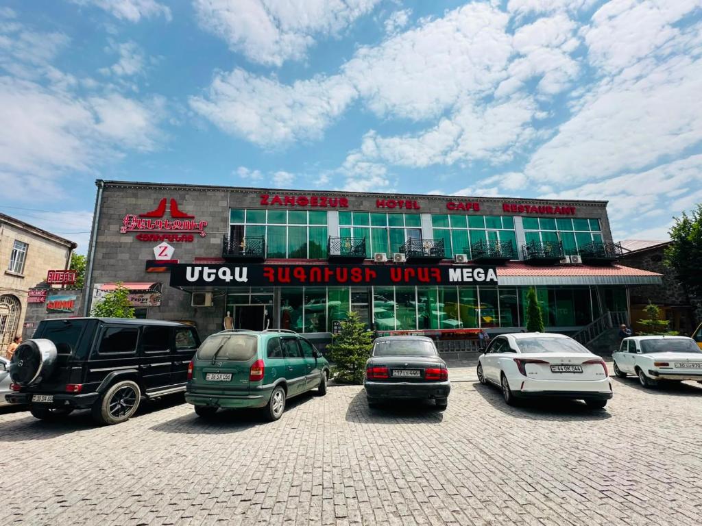 a building with cars parked in a parking lot at Zangezur Hotel in Goris