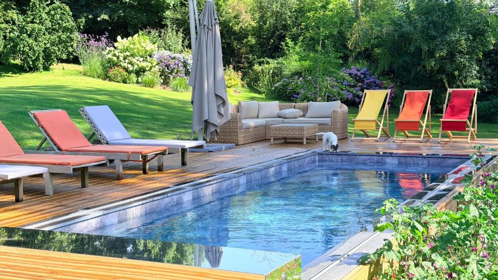 a patio with chairs and a swimming pool at La Plonploniere in Aix-en-Issart