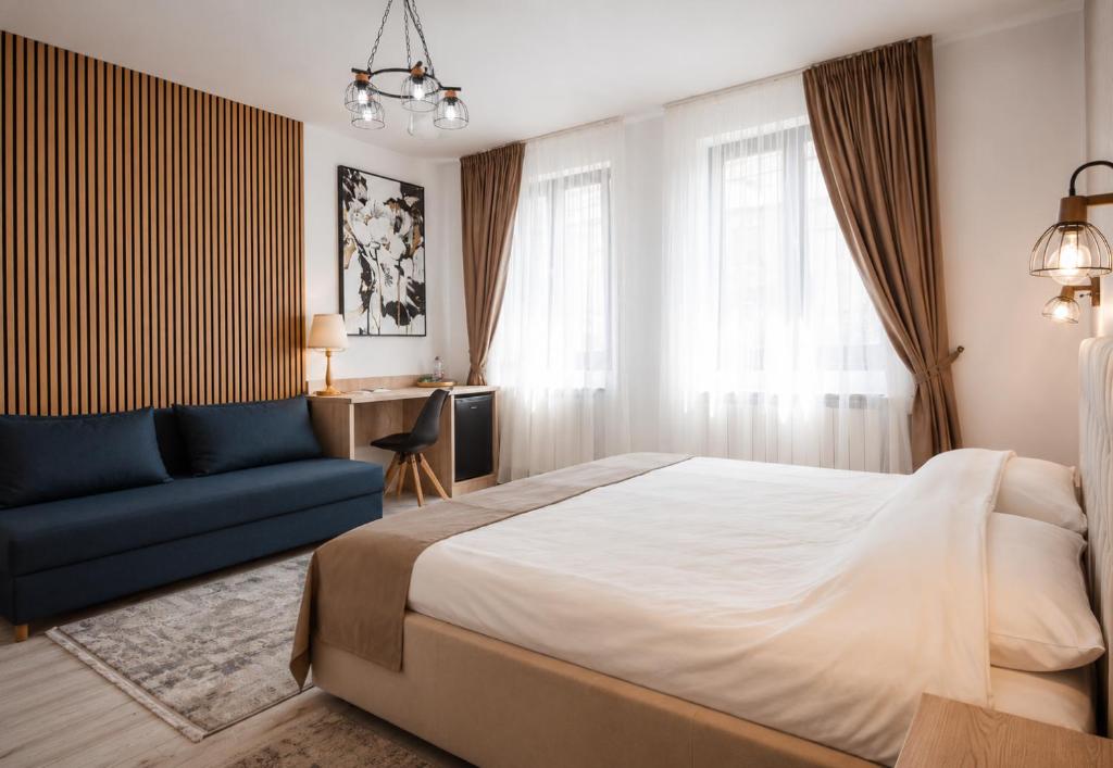 a bedroom with a bed and a blue couch at ARINI WHITE HOUSE in Sibiu