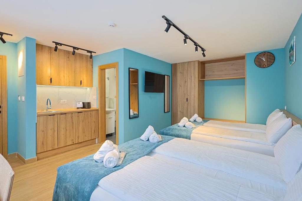 two beds in a room with blue walls at FourMountains-Bjelašnica in Sarajevo
