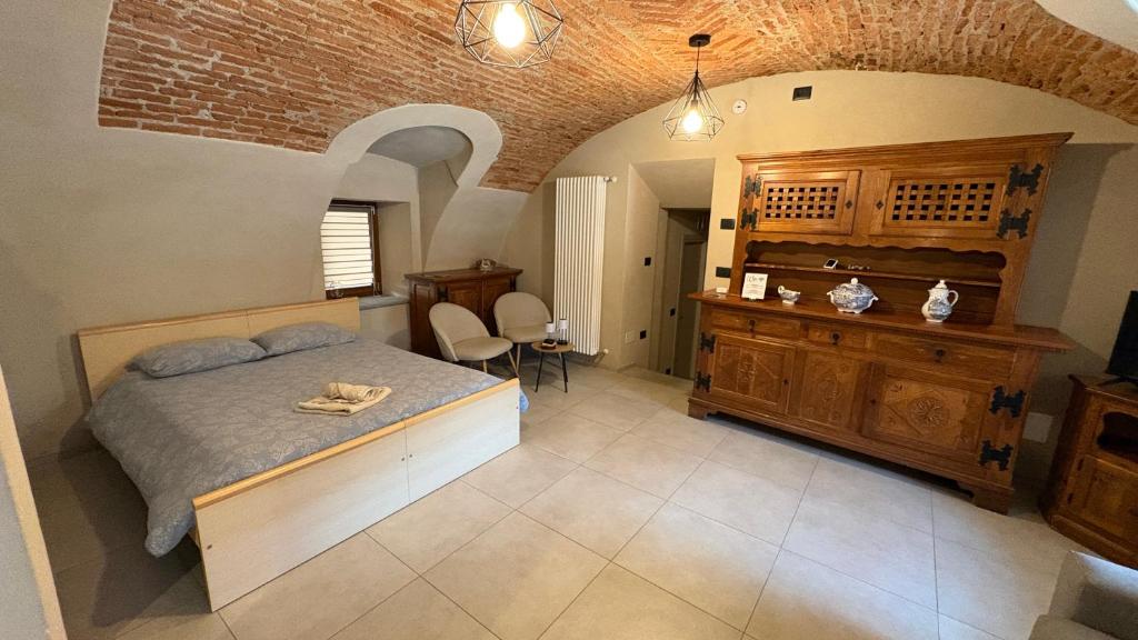 a bedroom with a bed and a wooden dresser at Il cortile in Boves