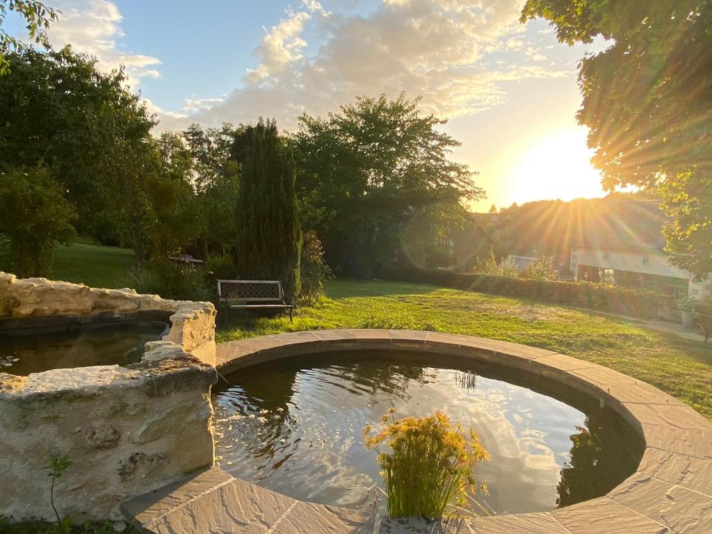 a pond in a garden with the sun setting at La Marmittiere in Civray-de-Touraine