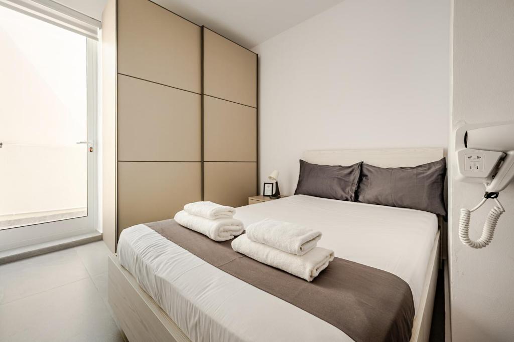 a bedroom with a white bed with towels on it at GZIRA F52 Bedroom in pethouse in Il-Gżira