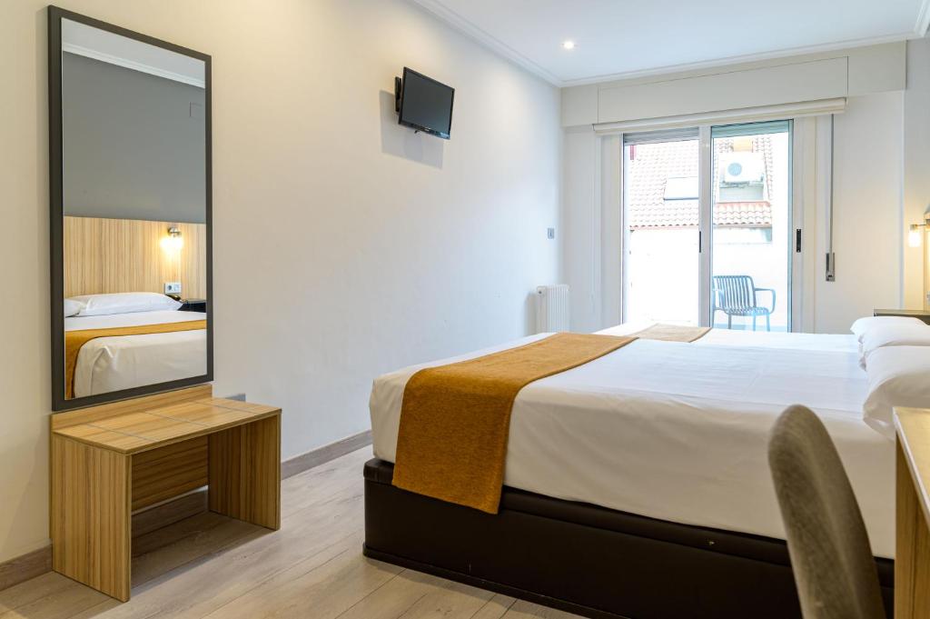 a bedroom with a large bed and a mirror at Alda Altiana in Ourense