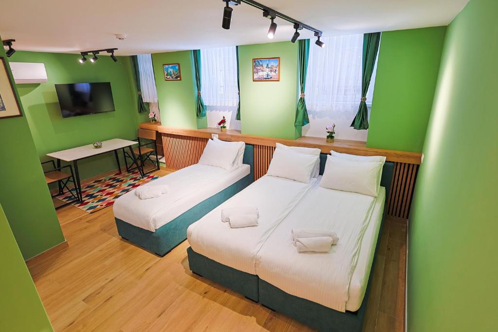 two beds in a room with green walls at FourMountains-Jahorina in Sarajevo