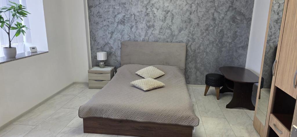 a bedroom with a bed with two pillows on it at Studio Central Brancusi in Târgu Jiu