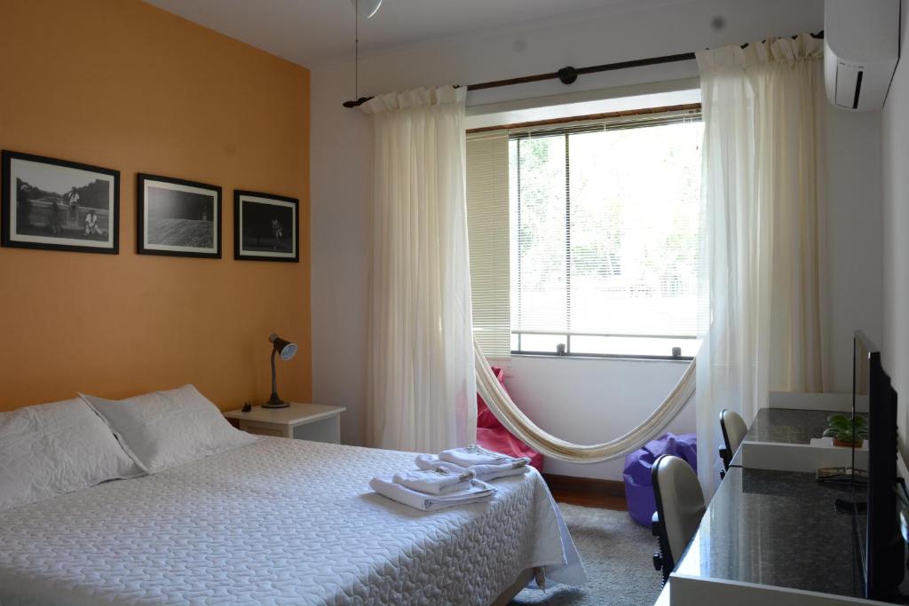 a bedroom with a bed and a window with a tub at Apartamento Kami in Porto Alegre