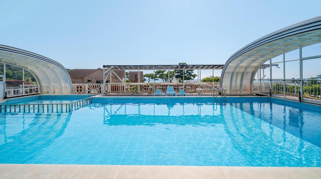a large swimming pool with blue water at Ganghwa Aiem Glamping in Incheon