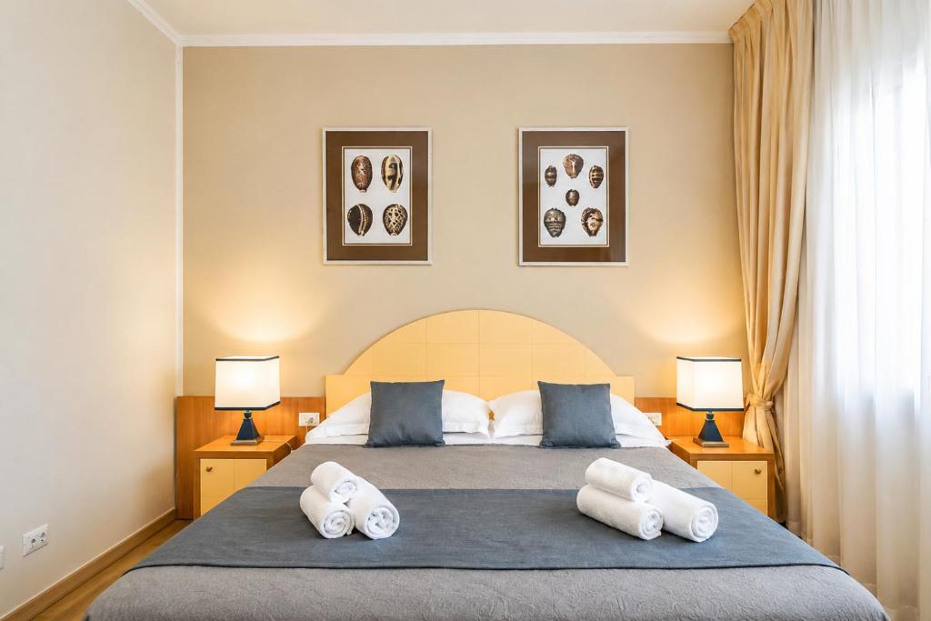 a bedroom with a large bed with two pillows at Hotel Stella D'Italia in Viareggio