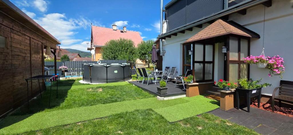 a small backyard with a yard with green grass at Apartmán U našich in Jeseník