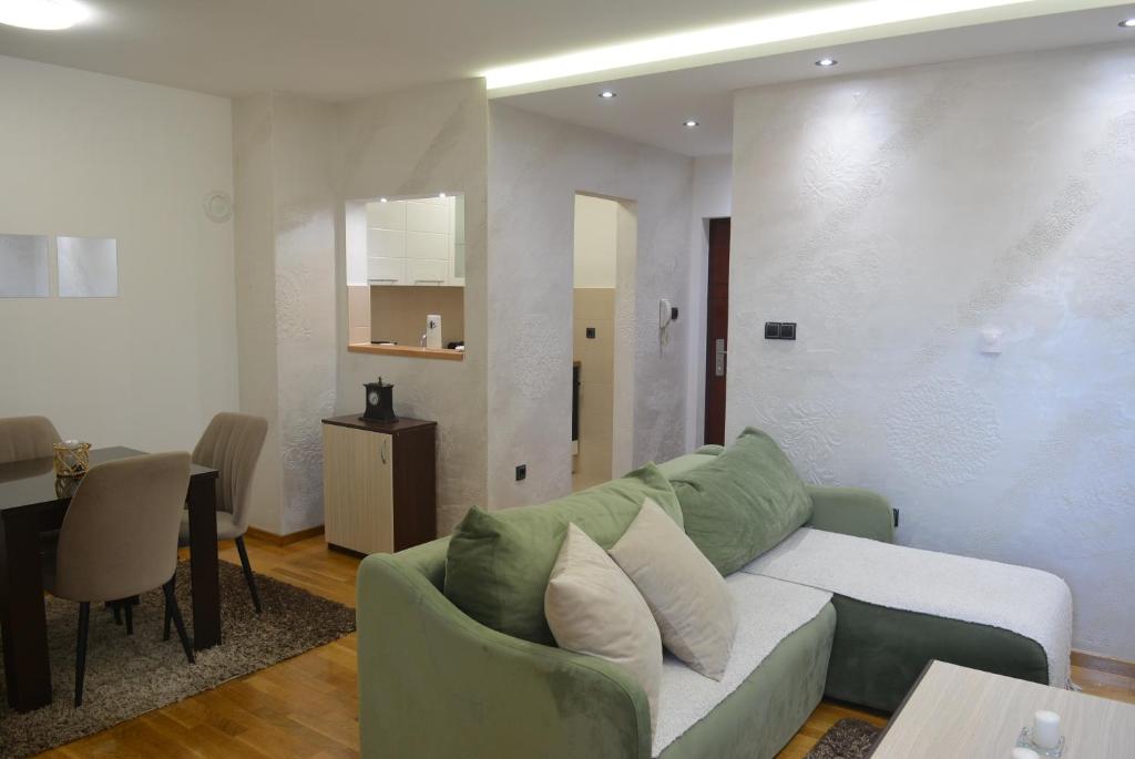 a living room with a green couch and a table at Rio Apartmani Ub 3 in Ub