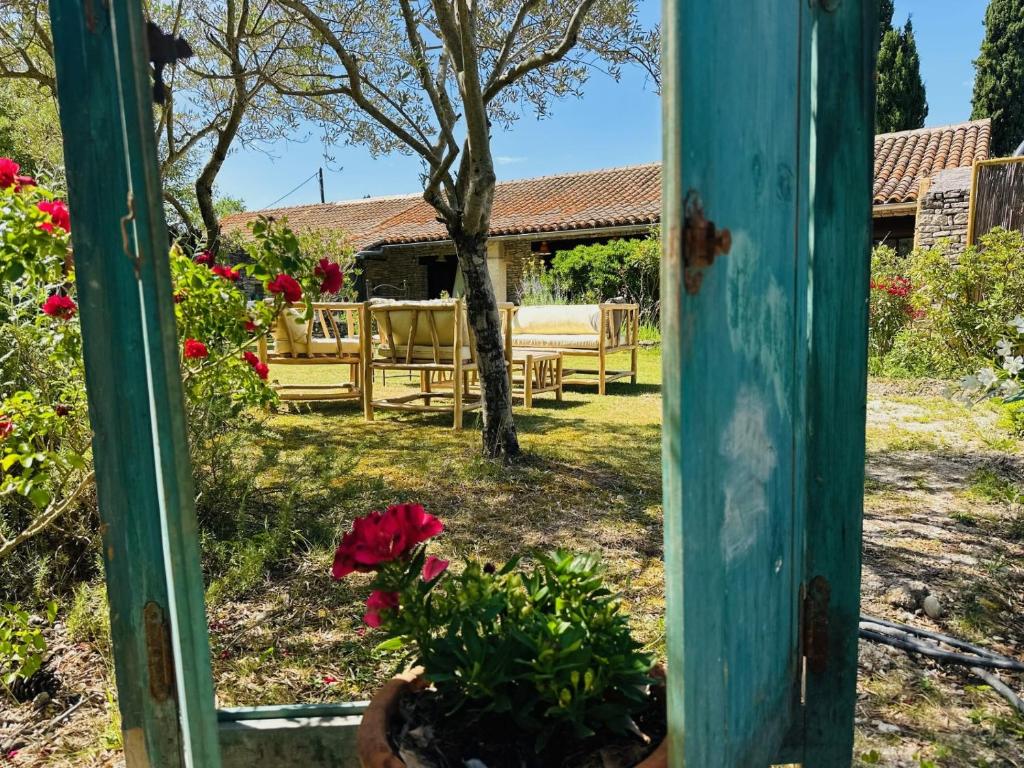 a window view of a garden with tables and flowers at Mas la Provence in L'Isle-sur-la-Sorgue