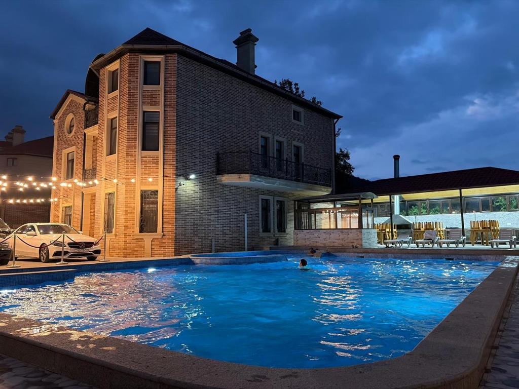 a large swimming pool in front of a building at Qusar Shahdag Garden Hotel in Qusar