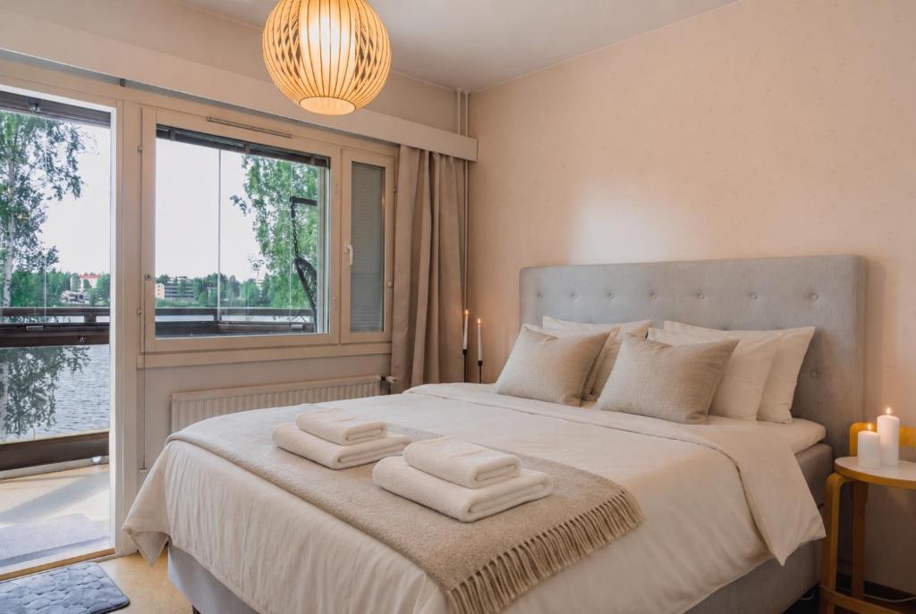 a bedroom with a large bed with towels on it at Nordic Nova II by Elys Collection in Rovaniemi