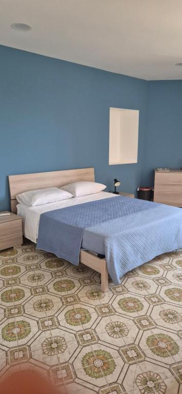 a blue bedroom with a bed and a blue wall at Officina Home in Caltanissetta