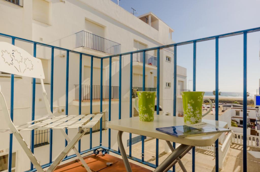balcón con mesa, sillas y vistas al océano en Apartamentos Carril de la Fuente, en Conil de la Frontera