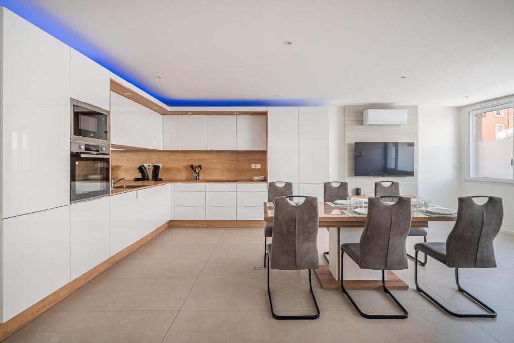 a kitchen with a dining table and chairs at Au coeur de Valence - Parking gratuit - Entièrement climatisé in Valence