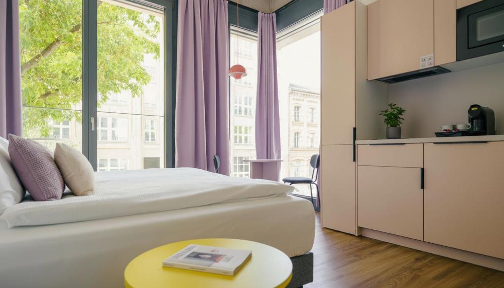 a hotel room with a bed and a large window at Homaris K48 Studios in Berlin