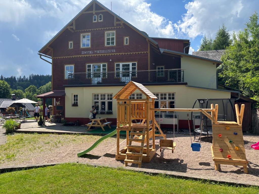 a playground in front of a large house at Hotel Večernice in Janske Lazne
