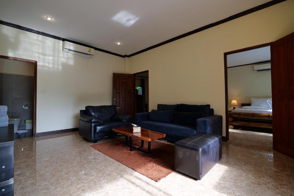 a living room with a couch and a table and a bed at Garden Resort in Ko Chang