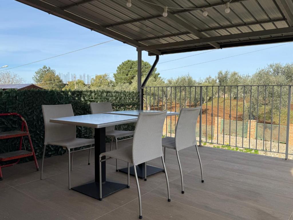 a table and chairs on a patio with a fence at Villa Melia Apartments in San Roberto