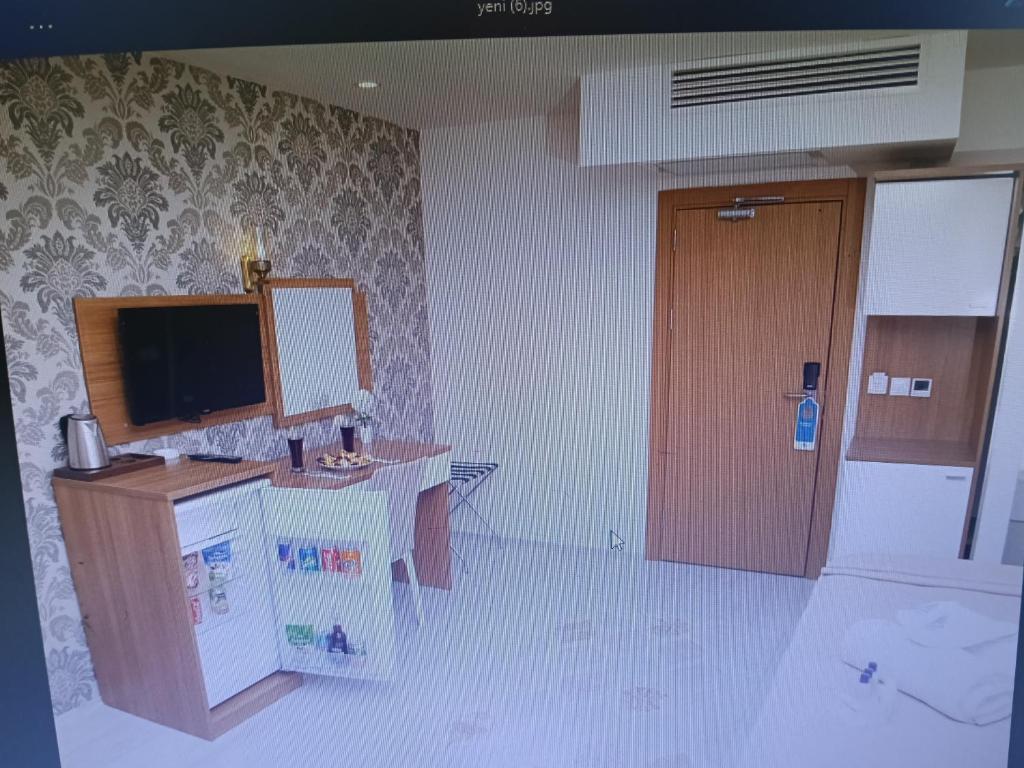 a room with a desk and a television and a door at FAVORİTE Hotel in Söğütlü