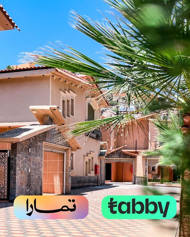 a house with a palm tree in front of it at فلل أرياف - Aryaf in Abha