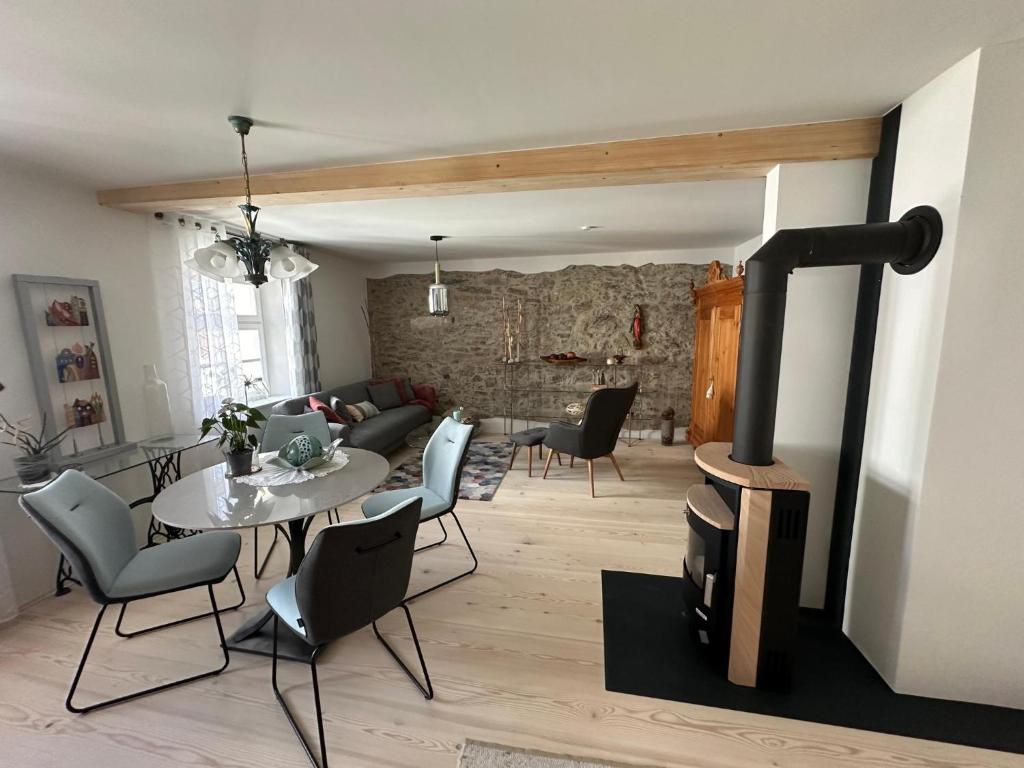 a living room with a table and a wood stove at Ferienwohnung im Künstlerhaus KUSCH in Schönsee