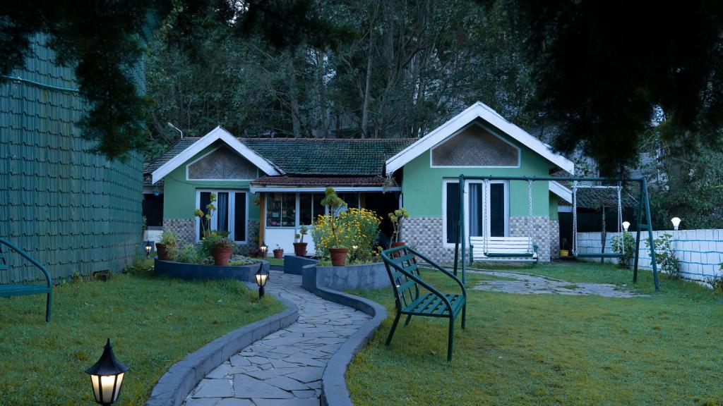 a green house with a bench in the yard at The Chill Inn ''Families Only'' By Green Leaves in Ooty