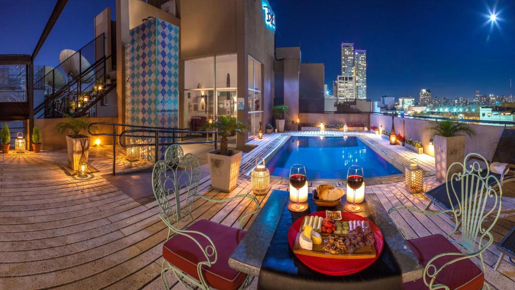 a rooftop patio with a swimming pool at night at Be Hollywood! in Buenos Aires