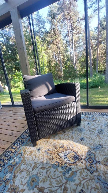 a wicker chair sitting on a rug on a porch at Kloogaranna Seaside Cottage in Kloogaranna