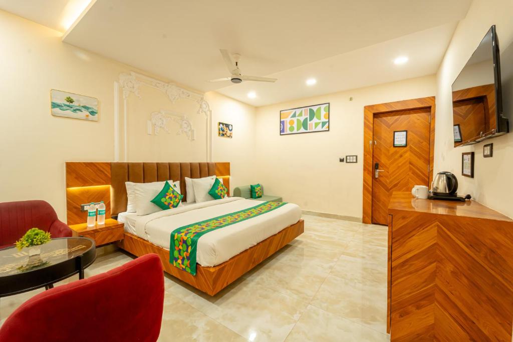 a hotel room with a bed and a chair and a table at Treebo Golden Palm, Civil Lines in Jabalpur